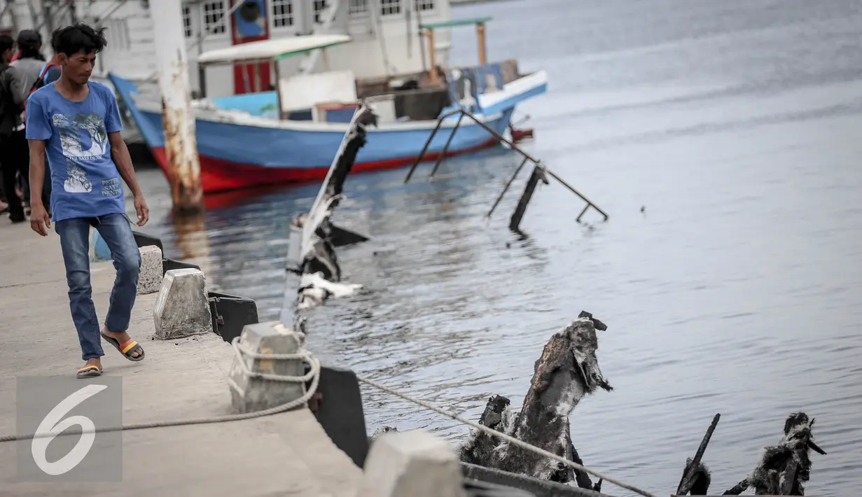 Warga melihat bangkai kapal Zahro yang terlihat hangus di pelabuhan Muara Angke, Jakarta, Selasa (3/1). Kondisi bangkai kapal yang terbakar pada Minggu (1/1) itu telah karam di sekitar dermaga Pelabuhan Kali Adem, Muara Angke. (Liputan6.com/Faizal Fanani)