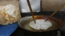 Seorang pedagang Suriah menggoreng panekuk tradisional yang dikenal sebagai "Naaem" yang biasa disajikan selama Ramadhan, di Shaqhoor Damaskus pada 28 April 2021. Betapa pun beratnya keadaan ekonomi, naeem adalah jawaban dari tradisi yang tidak bisa ditinggalkan selama Ramadhan. (LOUAI BESHARA/AFP)
