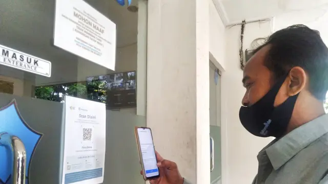 Salah seorang staf di lingkungan Sekterarit Daerah (Setda) Garut, Jawa Barat tengah menggunakan aplikasi Peduli Lindungi.