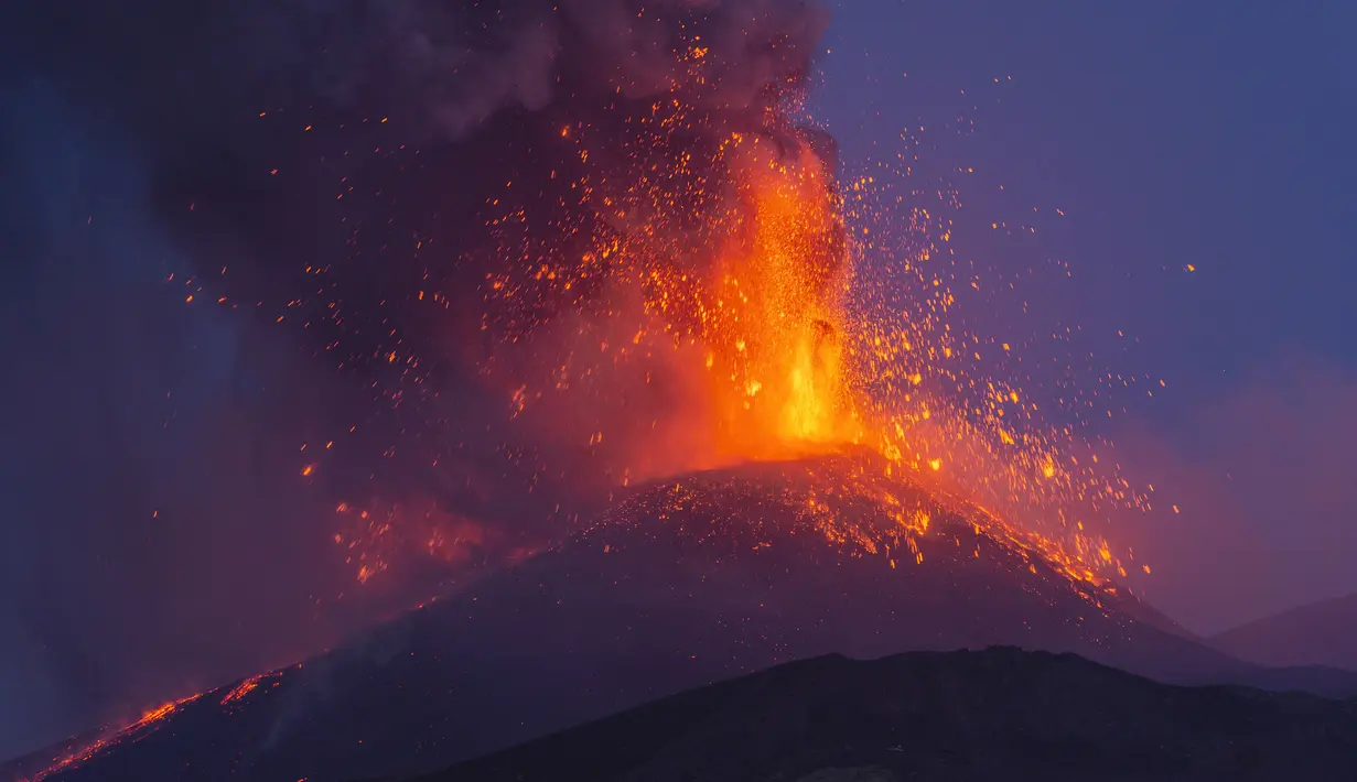Asap mengepul dari Gunung Etna seperti yang terlihat dari Milo, Sisilia, Italia, Senin (9/8/2021). Gunung berapi paling aktif di Eropa tersebut menyemburkan abu vulkanik dan lava pijar ke sekitar area berpenduduk padat di lerengnya. (AP Photo/Salvatore Allegra)