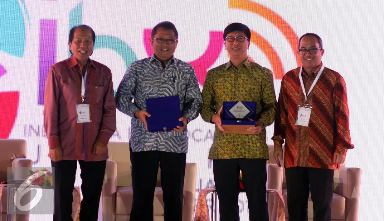 Menteri Komunikasi dan Informatika Rudiantara (kedua kiri) dan CEO SCM Sutanto Hartanto (kedua kanan) mendapat cinderamata usai menjadi pembicara di Indonesia Broadcasting Expo (IBX) 2016, Jakarta, Jumat (21/10). (Liputan6.com/Helmi Afandi) 