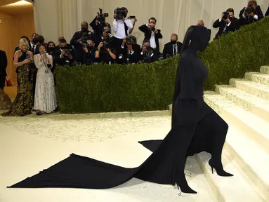 Kim Kardashian menghadiri gelaran Met Gala 2021 di Metropolitan Museum of Art, New York City, Senin (13/9/2021). Kim Kardashian muncul dengan gaya busana yang ekstrem dalam balutan baju serba hitam lengkap dengan topeng yang menutup total wajahnya. (Evan Agostini/Invision/AP)