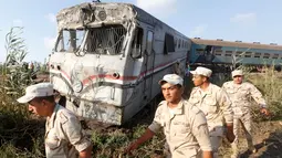 Petugas keamanan setempat berkeliling disekitar lokasi tabrakan kereta di Kota Alexandria, Mesir (11/8). Dikabarkan kecelakaan tersebut terjadi pukul 14.15 waktu setempat di dekat stasiun Khorshid. (AP Photo/Ravy Shaker)