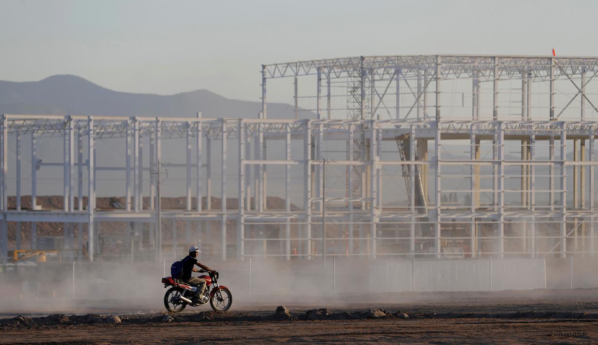 Pekerja mengendarai motor di lokasi proyek pembangunan Pabrik Ford di Villa de Reyes, San Luis Potosi, Meksiko, (4/1). Ford mengumumkan pembatalan pembangunan pabrik baru di negara tersebut. (AP Photo/Rebecca Blackwell)