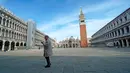 Seorang wanita berjalan di Lapangan Santo Markus, Venesia, Italia, Senin (9/3/2020). Hingga saat ini, sebanyak 9.172 pasien di Italia dinyatakan positif virus corona (COVID-19). (Anteo Marinoni/LaPresse via AP)