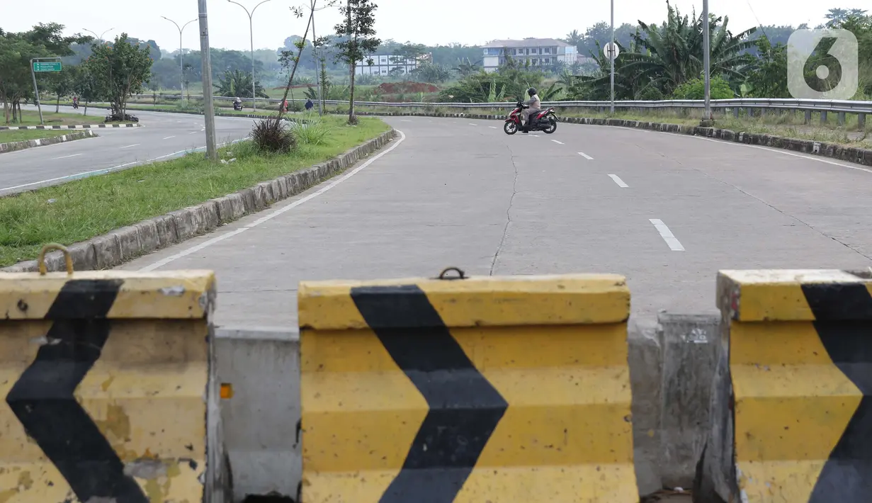Pengendara motor berbalik arah melihat beton pembatas di kawasan lingkar Stadion Pakansari, Kabupaten Bogor, Jawa Barat, Rabu (10/6/2020). Pemkab Bogor masih melakukan Pembatasan Sosial Berskala Besar (PSBB) secara proporsional hingga 2 Juli mendatang. (Liputan6.com/Helmi Fithriansyah)