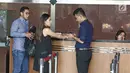 Dwina Michaella dan Rheza Herwindo mengisi buku tamu usai menjalani pemeriksaan di gedung KPK, Jakarta, Rabu (28/3). Dwina dan Rheza diperiksa sebagai saksi untuk tersangka Irvanto Hendra Pambudi Cahyo dan Made Oka Masagung. (Liputan6com/Herman Zakharia)