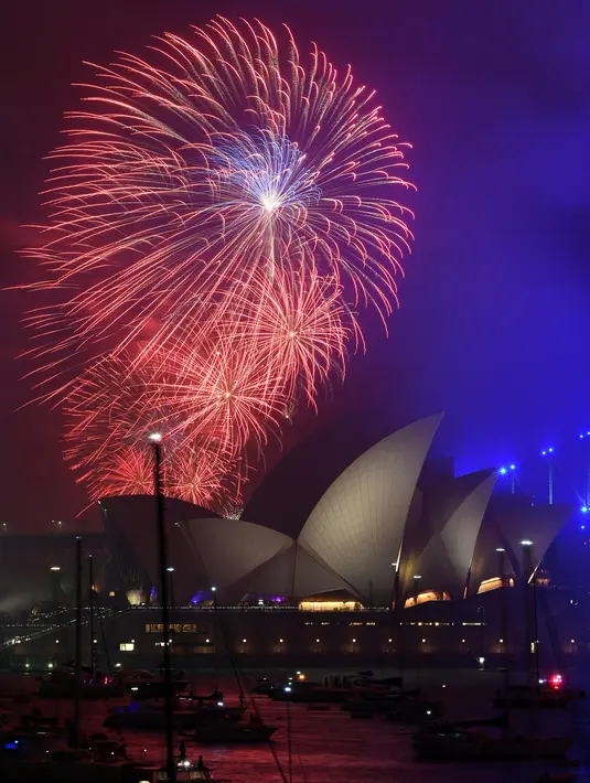 Kembang api menghiasi langit di atas Gedung Opera dan Jembatan Harbour sekitar 3 jam saat pergantian tahun di Sydney (01/1/2018). Langit di Sydney dihujani 13 ribu kembang api jenis shell dan 30 ribu kembang api jenis komet. (AFP Photo / Saeed Khan)