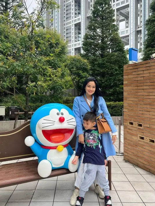 Boyong orangtua dan anak liburan di Jepang, Titi Kamal tampil menawan dengan long coat warna biru cerah. [Foto: IG/titi_kamall].