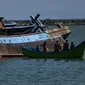 Petugas bersiap menenggelamkan kapal asing ilegal asal Malaysia di perairan Pelabuhan Perikanan Samudera Kutaraja, Banda Aceh (18/3/2021). Dua kapal asing asal Malaysia tersebut diledakkan dan ditenggelamkan setelah diputus bersalah dalam perkara tindak pidana perikanan. (AFP/Chaideer Mahyuddin)