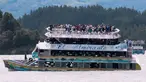 Penumpang terlihat berada di atas kapal wisata Almirante sesaat sebelum tenggelam di sebuah waduk di Kolombia barat daya, Minggu (25/6). Sedikitnya sembilan orang meninggal dunia dan 28 lainnya hilang dalam peristiwa itu. (Juan QUIROZ/AFPP)