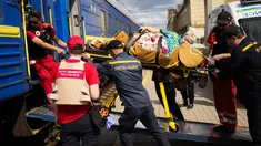 Seorang pasien dibawa dengan tandu untuk menaiki kereta evakuasi medis yang dijalankan oleh MSF (Doctors Without Borders) di stasiun kereta api di Pokrovsk, Ukraina timur, Minggu (29/5/2022). Kereta tersebut dilengkapi dikelola oleh tenaga medis, dan mengangkut pasien dari rumah sakit yang kewalahan di dekat garis depan, ke fasilitas medis di Ukraina barat, jauh dari pertempuran. (AP Photo/Francisco Seco)