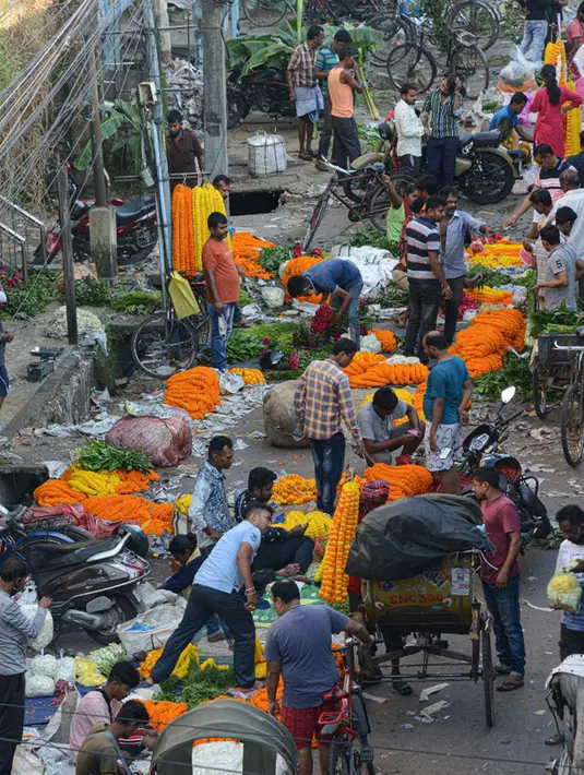Para pedagang menjajakan bunga untuk dijual selama Festival Durga Puja di pinggir jalan Siliguri, India, Selasa (12/10/2021). Durga Puja juga disebut Durgotsab adalah festival tahunan di Asia Selatan untuk memuja dewi Durga dari agama Hindu. (DIPTENDU DUTTA/AFP)