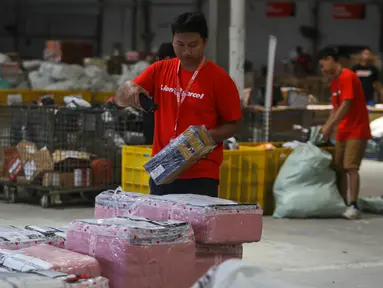 Pekerja menyortir paket yang akan dikirim ke berbagai kota di Mega Hub Lion Parcel, Kota Tangerang, Banten, Rabu (18/12/2024). (Liputan6.com/Angga Yuniar)