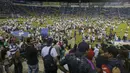 Para suporter berhamburan ke dalam lapangan saat terjadi kerusuhan suporter akibat saling berebut masuk ke dalam Stadion Monumental, Cuscatlan, San Salvador, El Salvador, Sabtu (21/5/2023) waktu setempat untuk menyaksikan laga perempatfinal Divisi Utama El Salvador antara Alianza FC menghadapi Deportivo FAS. (AP Photo/Milton Flores)