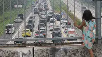 Kemacetan yang terjadi di lajur Cipali setelah gerbang tol Palimanan, Kabupaten Cirebon, Jawa Barat, menjadi&nbsp;'objek wisata' masyarakat yang tinggal di sekitar gardu tol. Mereka biasanya menyaksikan momen tahunan tersebut dari jembatan penyeberangan yang tepat berada di atas gerbang tol Palimanan tersebut. (FOTO / Inung Budiarto)