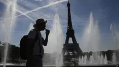 Seorang pria mendinginkan diri di dekat air mancur Trocadero, di tengah suhu tinggi di Paris, Kamis (16/6/2022). Prancis akan mengalami suhu yang memecahkan rekor mendekati 40 derajat Celcius pada Juni, karena gelombang panas dini yang diperkirakan akan melanda sebagian besar negara itu. (JULIEN DE ROSA / AFP)