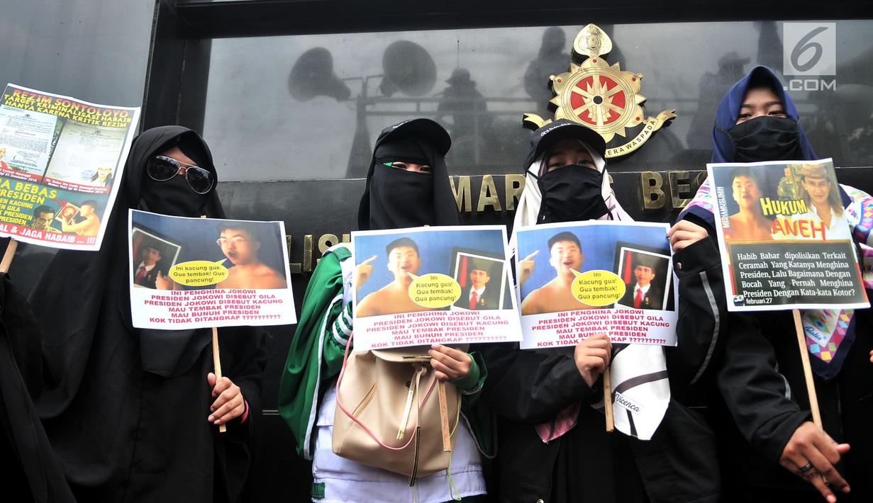 Massa Laskar Pembela Islam (LPI) membawa poster tuntutan saat mengawal pemeriksaan Habib Bahar bin Smith di depan Gedung Bareskrim Polri, Jakarta, Kamis (6/12). Massa LPI menuntut keadilan hukum bagi Habib Bahar. (Merdeka.com/Iqbal Nugroho)