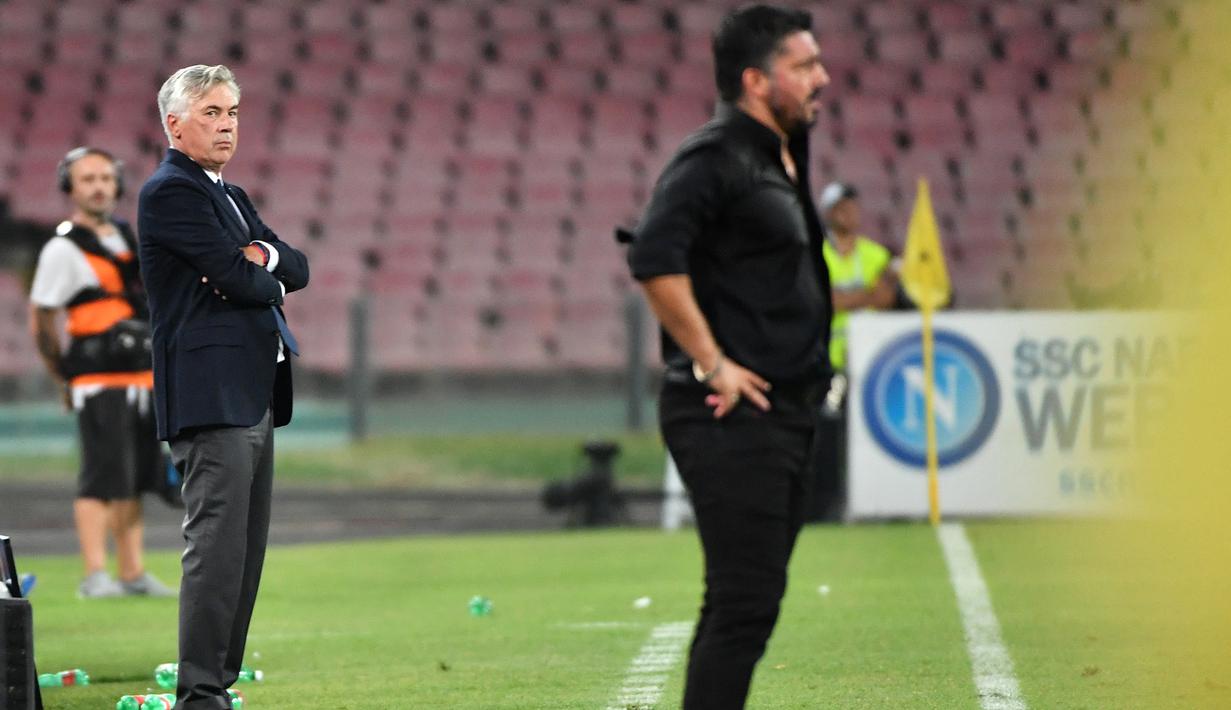 Pelatih Napoli, Carlo Ancelotti (kiri) dan pelatih AC Milan, Gennaro Gattuso melihat para pemainnya bertanding pada lanjutan Liga Serie A Italia di San Paolo Stadium, Naples (25/8). Napoli menang tipis atas Milan 3-2. (AFP Photo/Alberto Pizzoli)