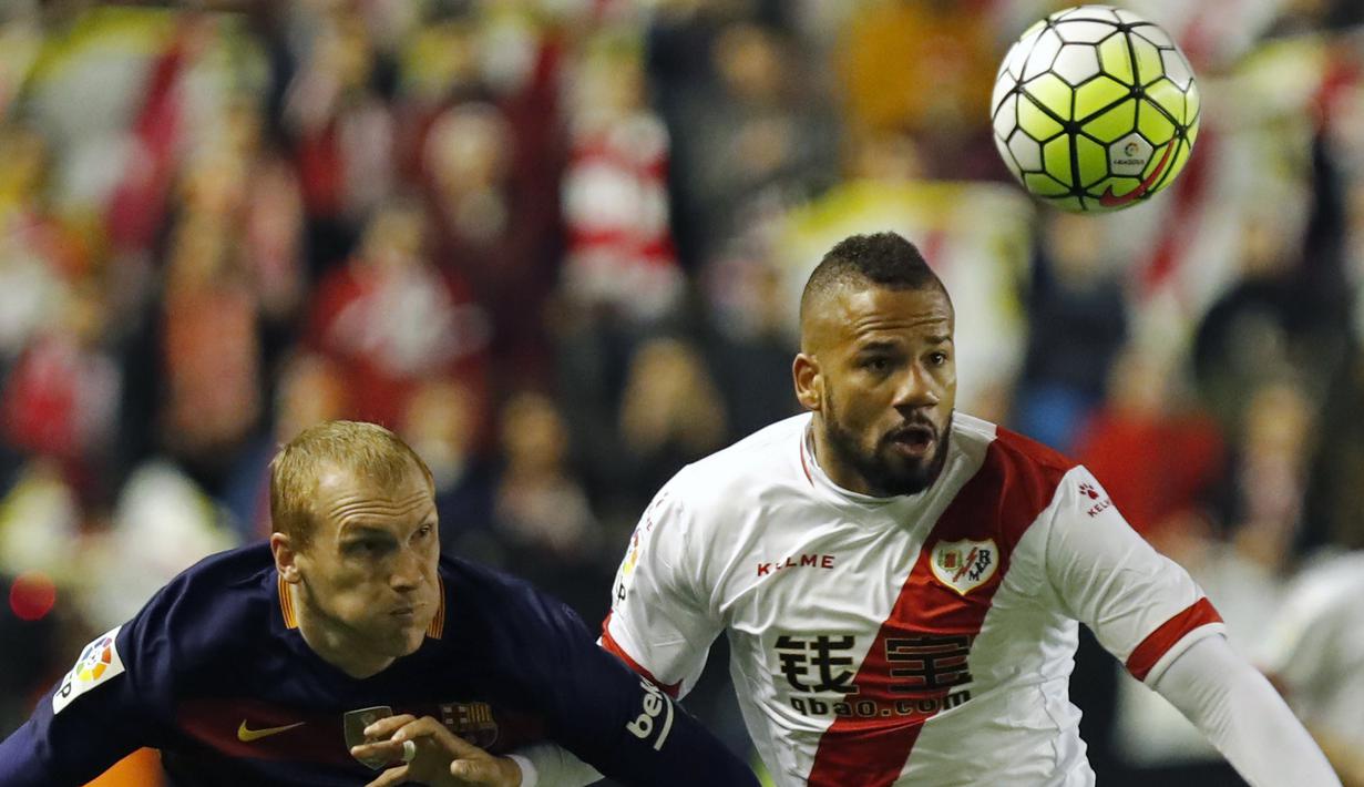 Pemain Barcelona, Jeremy Mathieu (kiri), berebut bola dengan pemain Rayo Vallecano, Bebe, pada laga La Liga Spanyol di Estadio del Rayo Vallecano, Madrid, Jumat (4/3/2016) dini hari WIB. (EPA/Javier Lizon)