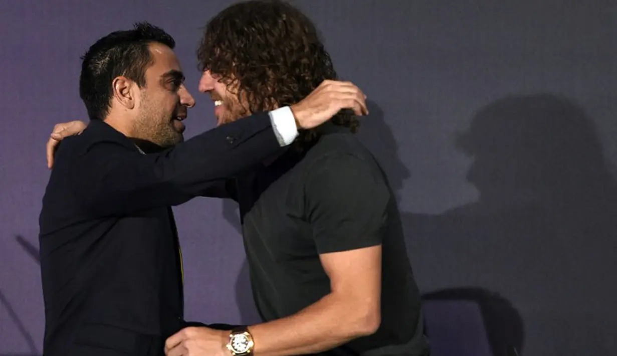 Gelandang Barcelona, Xavi Hernandez (kiri) memeluk Carles Puyol saat konferensi pers perpisahan Carles Puyol di stadion Camp Nou, Barcelona, (15/5/2014). (AFP PHOTO/Lluis Gene)