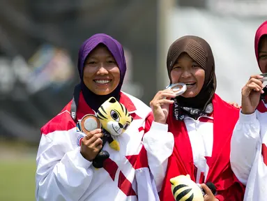 Tim Panahan Putri Indonesia, Diananda Chairunisa, Linda Lestari, Titik Kusumawardani, menunjukkan medali perak nomor beregu putri recurve SEA Games 2017 di MSN Archery Centre, Kuala Lumpur, Malaysia, Senin (21/8). (Liputan6.com/Faizal Fanani)