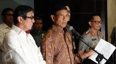 Menkopolhukam Wiranto (tengah) bersama Menkumham, Mendagri dan Kapolri menunjukkan surat pernyataan di Jakarta, Senin (8/5). Wiranto membacakan pernyataan pemerintah terkait pembubaran ormas Hizbut Tahrir Indonesia. (Liputan6.com/Helmi Fithriansyah)