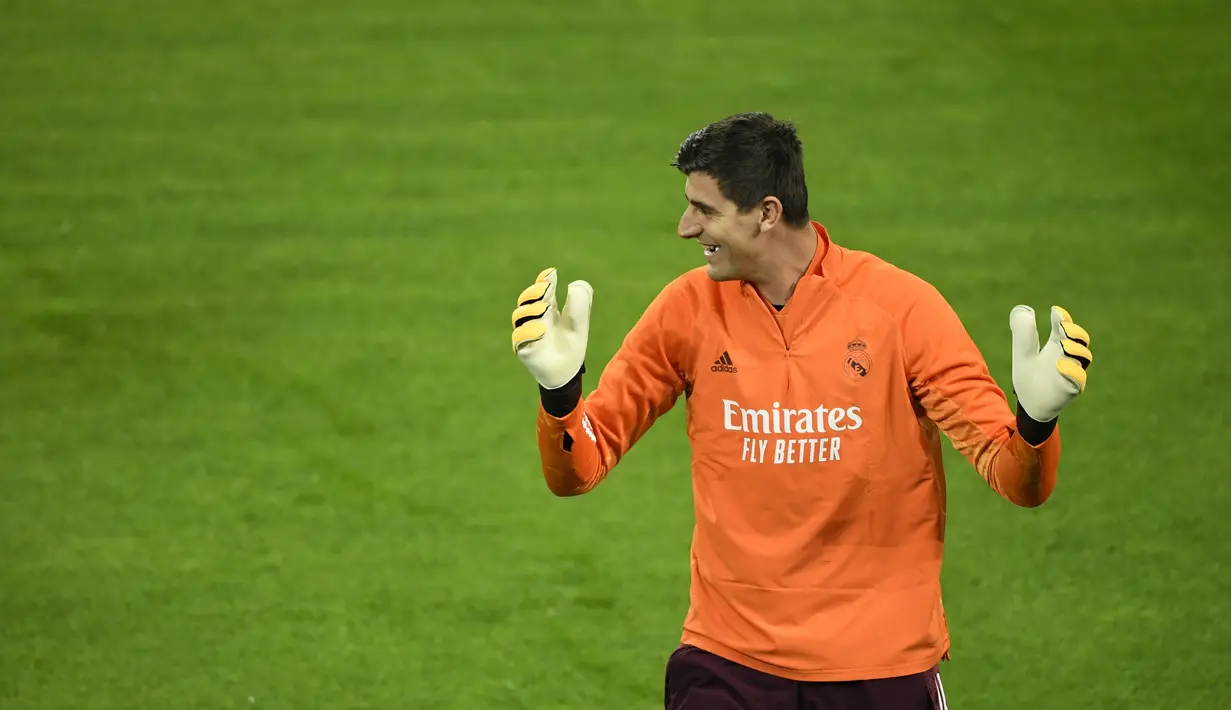 Kiper Real Madrid, Thibaut Courtois tertawa saat mengikuti latihan tim di Borussia-Park, Jerman (26/10/2020). Real Madrid akan bertanding melawan Borussia Moenchengladbach pada grup B Liga Champions. (AFP/Ina Fassbender)