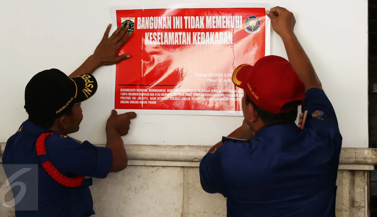 Petugas Damkar Menyegel bangunan Hotel De Rivier kawasan Kota Tua, Jakarta, Selasa (18/10). Penyegelan dilakukan karena pihak hotel melanggar Perda nomor 8 tahun 2008 tentang Pencegahan dan Penanggulangan Bahaya Kebakaran. (Liputan6.com/Gempur M Surya)