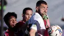 Striker Real Madrid, Karim Benzema, berebut bola dengan pemain Elche, Johan Mojica, pada laga Liga Spanyol di Stadion Alfredo di Stefano, Sabtu (13/3/2021). Real Madrid menang dengan skor 2-1. (AP/Bernat Armangue)