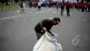 Pemulung memungut botol plastik saat peringatan hari buruh sedunia yang jatuh pada tanggal 1 Mei di depan Istana Merdeka, Jakarta, Jumat (1/5/2015). Aksi demo May Day menyisahkan sejumlah sampah berserakan di jalan. (Liputan6.com/Faizal Fanani)