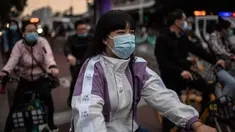 Orang-orang yang memakai masker untuk mengurangi risiko tertular virus corona COVID-19 sedang menunggu di lampu merah saat mereka bepergian dengan sepeda selama jam sibuk di Beijing, China pada 14 Oktober 2020. (Photo by NICOLAS ASFOURI / AFP)
