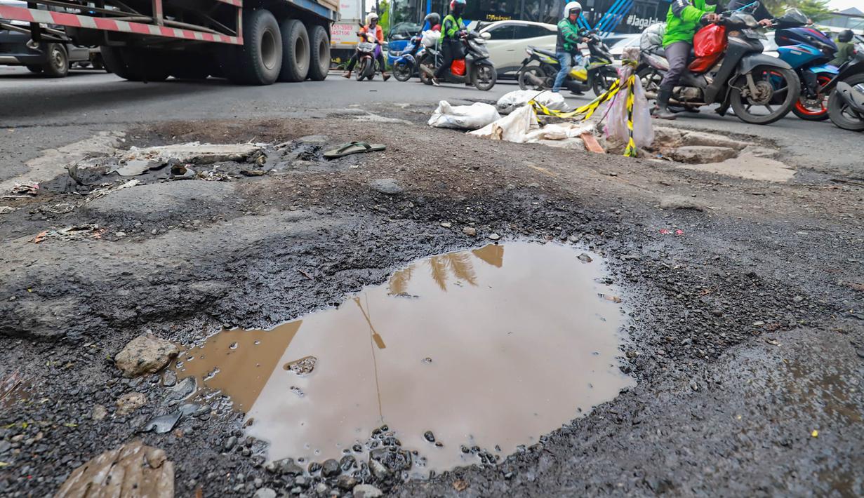 Jumlah tersebut meningkat signifikan dibandingkan Desember 2025 seiring tingginya intensitas hujan sejak awal Januari 2026. Tampak dalam foto, sejumlah pengendara melewati kerusakan di Jalan Mitra Bahari, Penjaringan Jakarta Utara, Selasa (3/2/2026). (merdeka.com/Arie Basuki)