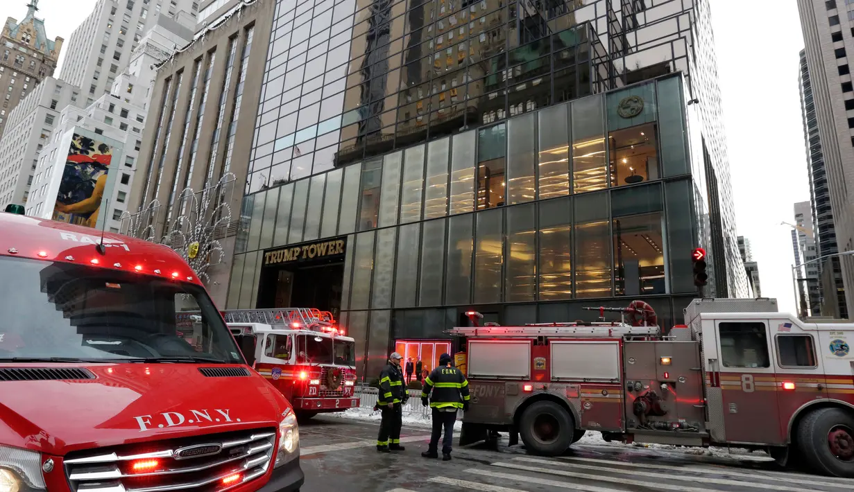 Kendaraan petugas pemadam berada di lokasi kebakaran di Fifth Avenue, depan Trump Tower, di New York, Senin (8/1). Sebanyak 84 petugas pemadam kebakaran dikerahkan untuk memadamkan api di puncak gedung berlantai 68 itu. (AP Photo/Richard Drew)