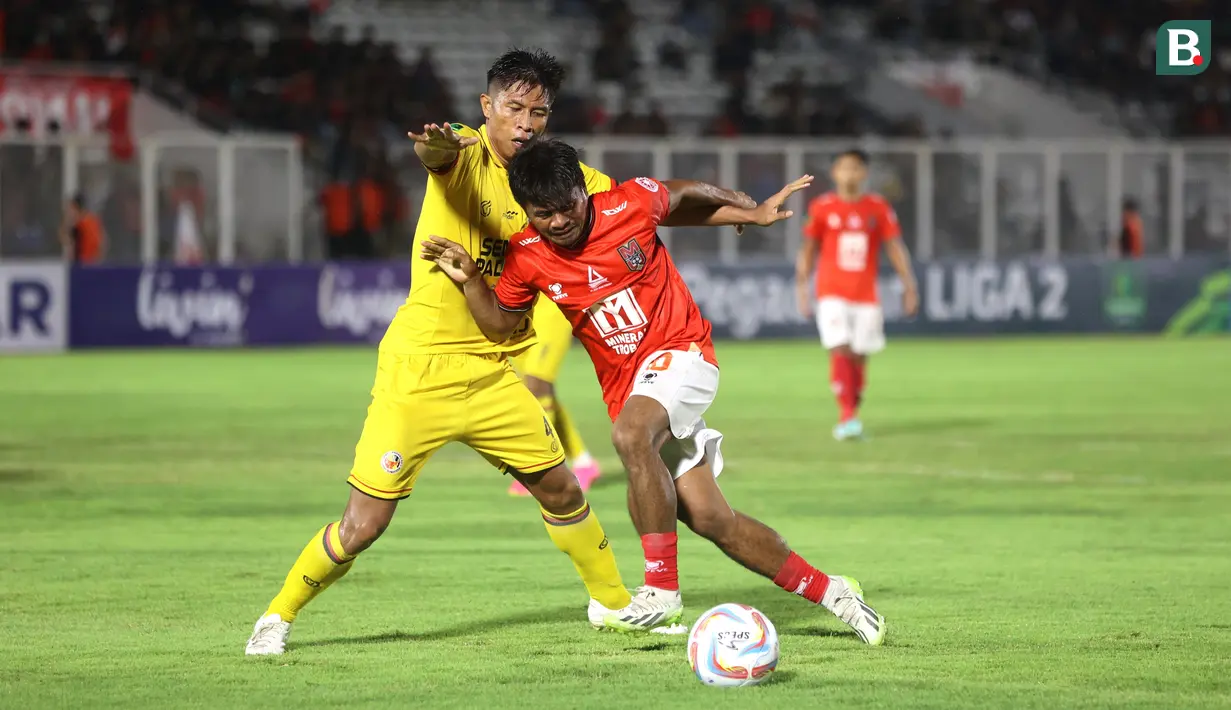 Pemain Malut United, Ilham Udin Armaiyn, berebut bola dengan pemain Semen Padang, Agus Nova, pada laga leg pertama semifinal Pegadaian Liga 2 2023/2024 di Stadion Madya, Jakarta, Minggu (25/02/2024). (Bola.com/M Iqbal Ichsan)