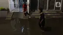 Warga sedang berjalan di tengah banjir yang melanda Jalan Bangka, Jakarta, Rabu (4/1/2023). Hujan deras yang terjadi pada Rabu sore membuat Kali Mampang meluap hingga menyebabkan banjir di kawasan tersebut dengan ketinggian bervariasi mulai dari 40 hingga 60 cm. (Liputan6.com/Herman Zakharia)