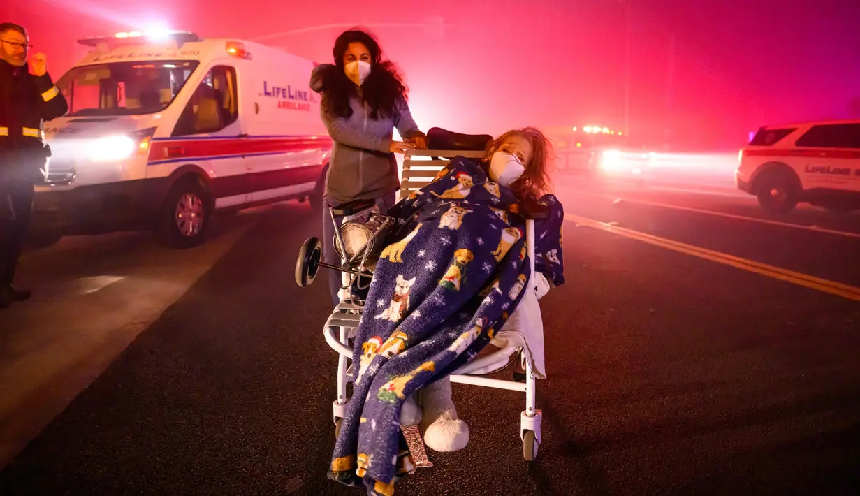 Pasien lanjut usia (lansia) dievakuasi menuju kendaraan darurat saat bara api mendekat saat kebakaran Eaton di Pasadena, California, Amerika Serikat pada tanggal 7 Januari 2025. (JOSH EDELSON/AFP)