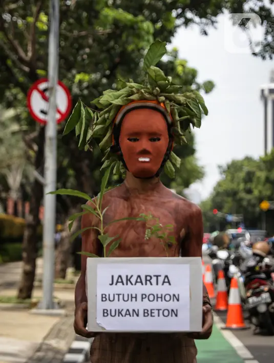 Aktivis Walhi membawa pohon saat menggelar aksi terkait proyek revitalisasi kawasan Monas di depan Balai Kota DKI Jakarta, Kamis (30/1/2020). Selain minta dihentikan, mereka juga mendesak kawasan Monas dikembalikan ke fungsi awal sebagai ruang terbuka hijau (RTH). (Liputan6.com/Faizal Fanani)