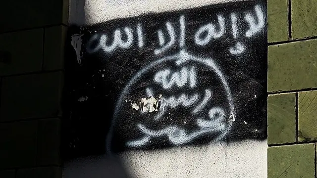 Gambar bendera Al-Qaeda pada sebuah tembok di Yemen.