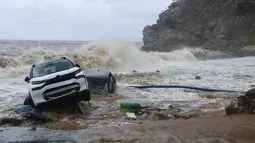 Mobil-mobil terlihat di tepi laut setelah badai petir hebat, di desa Paliokastro, di pulau Kreta, Yunani, Sabtu (15/10/2022). Dilaporkan setidaknya satu orang tewas dan lainnya hilang setelah banjir bandang yang parah. (AP Photo/Harry Nakos)