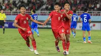 Striker Timnas Indonesia U-16, Muhammad Mierza, melakukan selebrasi seusai mencetak gol ke gawang Singapura U-16 bersama Fabio Azka Irawan (kiri) dan I Putu Panji Apriawan (kanan) di Stadion Manahan, Solo, Jumat (21/6/2024). (Bola.com/Radifa Arsa)