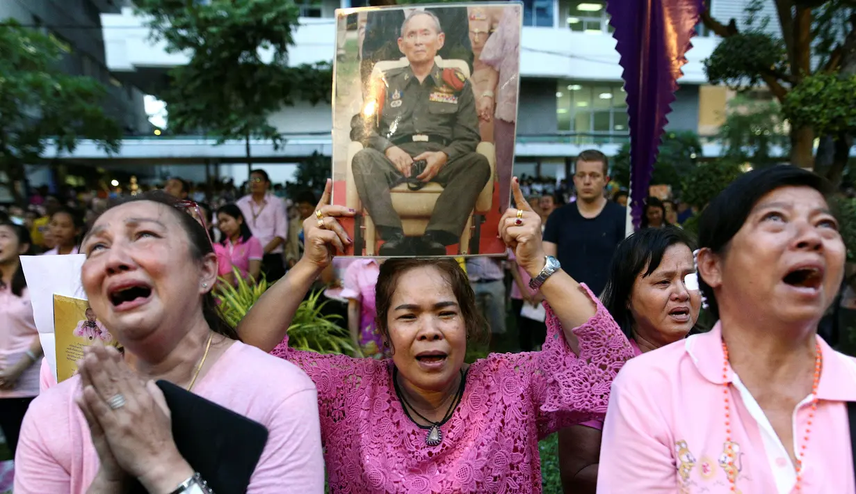 Warga membawa gambar Raja Thailand Bhumibol Adulyadej di RS Siriraj, Bangkok, Thailand, Kamis (13/10). Hingga akhir hayatnya, Raja Bhumibol Adulyadej merupakan raja yang paling lama berkuasa di dunia. (REUTERS / Chaiwat Subprasom)