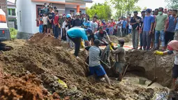 Warga membawa sisa-sisa korban tsunami dan gempa 2004 yang ditemukan di Kajhu, Provinsi Aceh (19/12). Penemuan korban tersebut membuat warga sekitar kaget dan berbondong-bondong menggali tanah di area sekitar. (AFP Photo/Chaideer Mahyuddin)