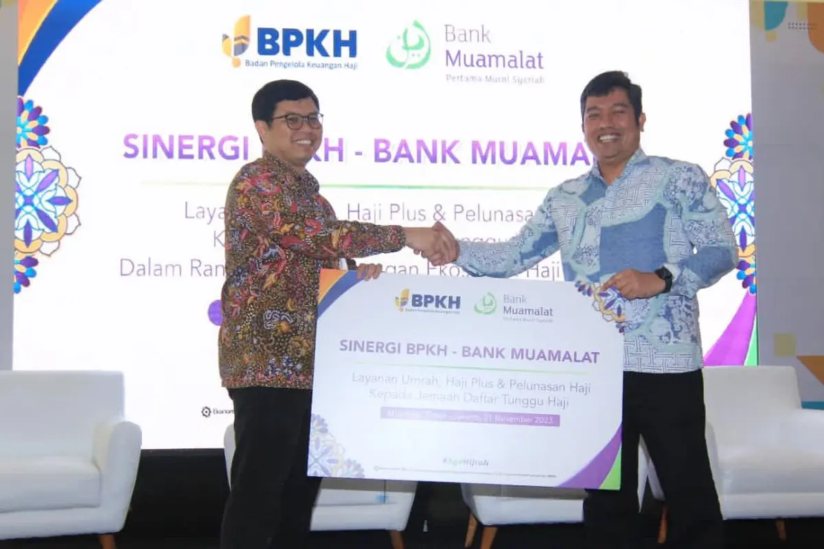 Anggota BPKH Harry Alexander (kanan) dan Direktur Utama Bank Muamalat Indra Falatehan (kiri) berfoto dengan memegang mockup Perjanjian Kerja Sama (PKS) layanan umrah, haji plus dan pelunasan haji kepada jemaah daftar tunggu di Jakarta, Selasa (21/11/2023)