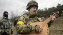 Taras Kompanichenko, seniman terkenal Ukraina dan relawan Pasukan Pertahanan Teritorial, memainkan kobza, alat musik gesek rakyat, pada upacara pernikahan Lesia Ivashchenko dan Valerii Fylymonov di pos pemeriksaan di Kiev, 6 Maret 2022 (AP/Efrem Lukatsky)