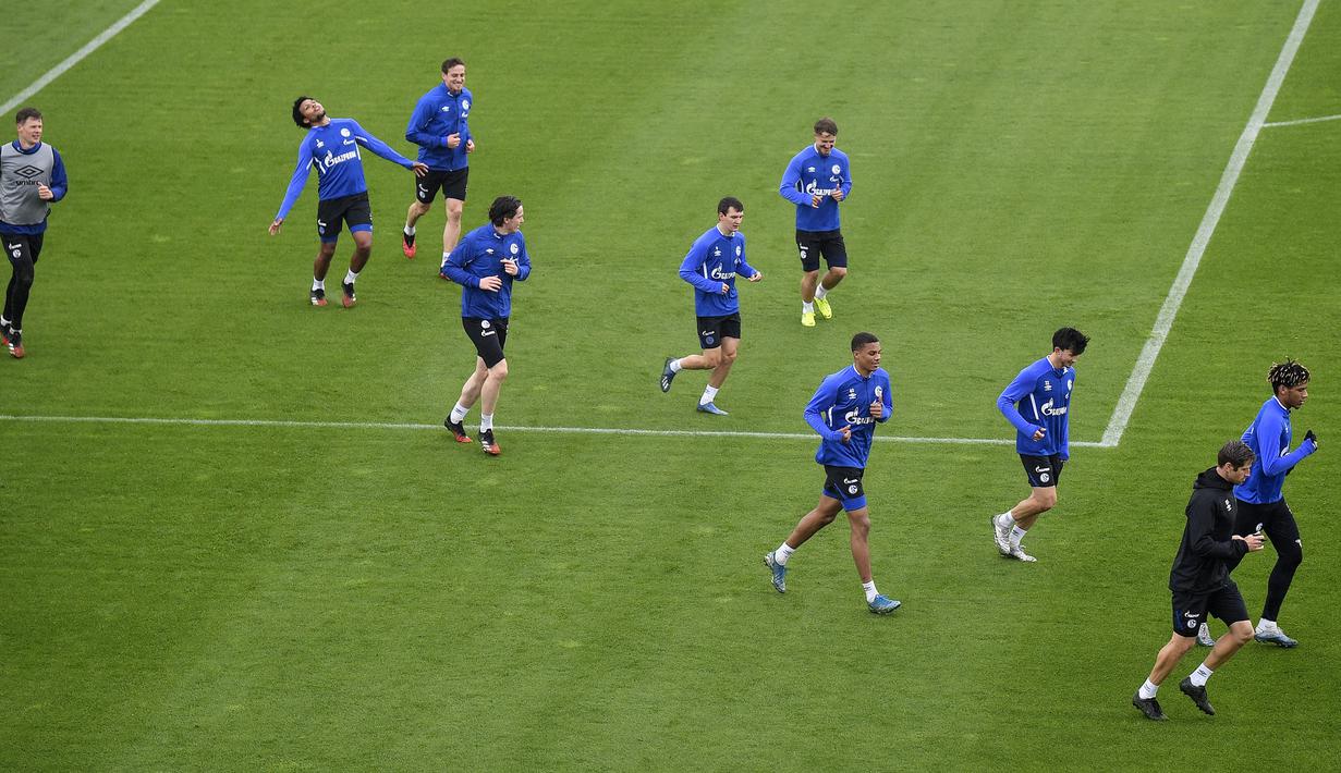 Pemain Schalke melakukan pemanasan lari saat mengikuti sesi latihan di Gelsenkirchen, Jerman, Rabu, (29/4/2020). Schalke kembali menggelar latihan jelang rencana akan kembali bergulirnya Bundesliga di tengah pandemi COVID-19 pada Mei mendatang. (AP/Martin Meissner)