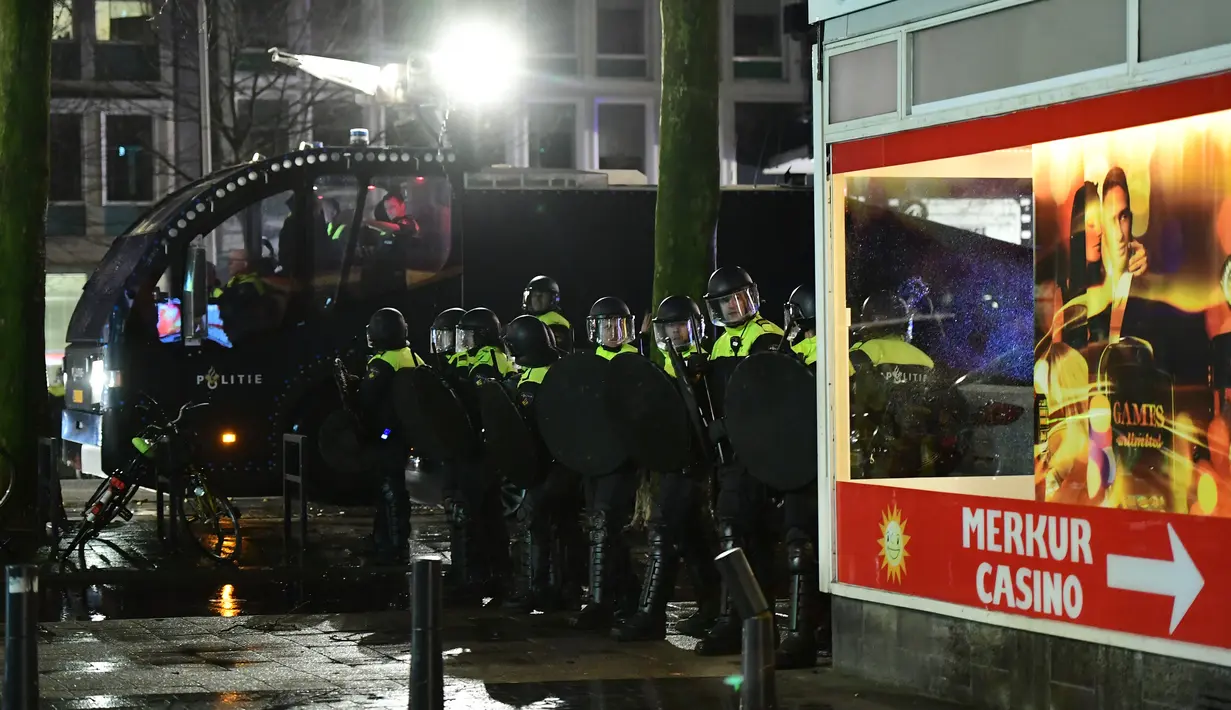 Polisi bersiap untuk mengamankan aksi protes yang digelar oleh warga Turki di Rotterdam, Belanda (11/3). Ketegangan ini terjadi beberapa jam setelah Mevlut Cavusoglu menyatakan akan terbang ke Rotterdam dan dilarang Belanda. (AFP/Emmanuel Dunand)