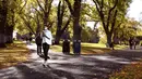 Seorang wanita berjalan sambil bermain ponsel di taman kota di Melbourne, Australia (3/6/2021). Pihak berwenang mengumumkan Lockdown di Melbourne diperpanjang tujuh hari lagi ketika negara itu berusaha untuk membasmi sekelompok kasus Covid-19 di Melbourne. (AFP Photo/William West)