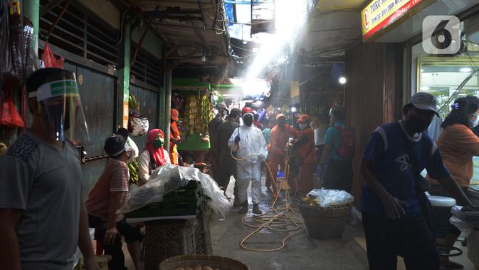 Petugas Palang Merah Indonesia (PMI) melakukan spraying pasar Karang Anyar dengan cairan disinfektan, Jakarta Pusat, Rabu (24/6/2020). Penyemprotan cairan disinfektan yang dilakukan tesebut untuk memutus penyebaran virus corona (COVID-19) pada PSBB Transisi new normal. (merdeka.com/Imam Buhori)