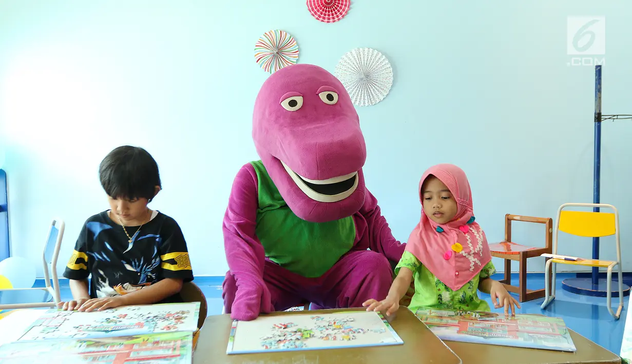 Karakter Boneka Barney membimbing anak-anak bermain puzzle jelang peringati Hari Anak Nasional yang jatuh pada 23 Juli 2017 di RS Siloam Asri, Jakarta, Sabtu (22/07). Permainan ini membantu anak-anak berpikir lebih fokus. (Liputan6.com/Fery Pradolo)